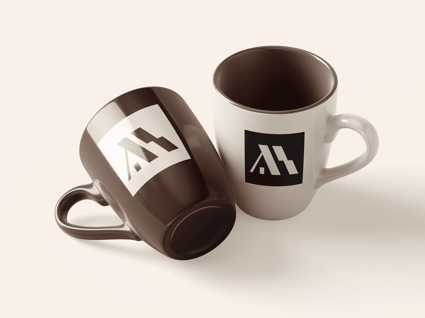 Two mugs, brown and cream, each with the symbol.